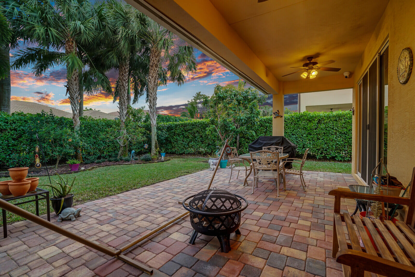 212 Behring Way Jupiter, FL 33458 - Photo 33 of 56 a view of a patio with table and chairs potted plants and palm tree