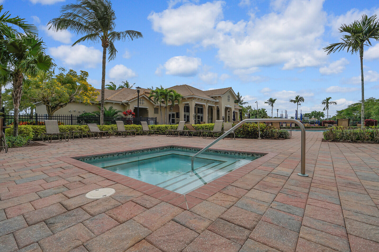 212 Behring Way Jupiter, FL 33458 - Photo 47 of 56 a view of a white house with a swimming pool and lawn chairs