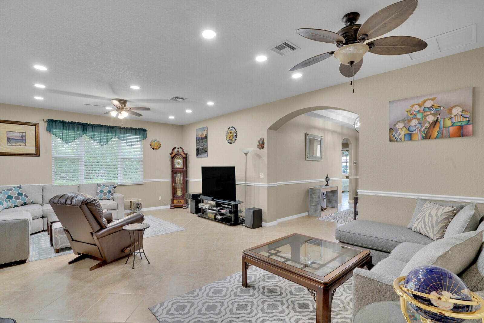 212 Behring Way Jupiter, FL 33458 - Photo 10 of 56 a living room with furniture and a flat screen tv with kitchen view