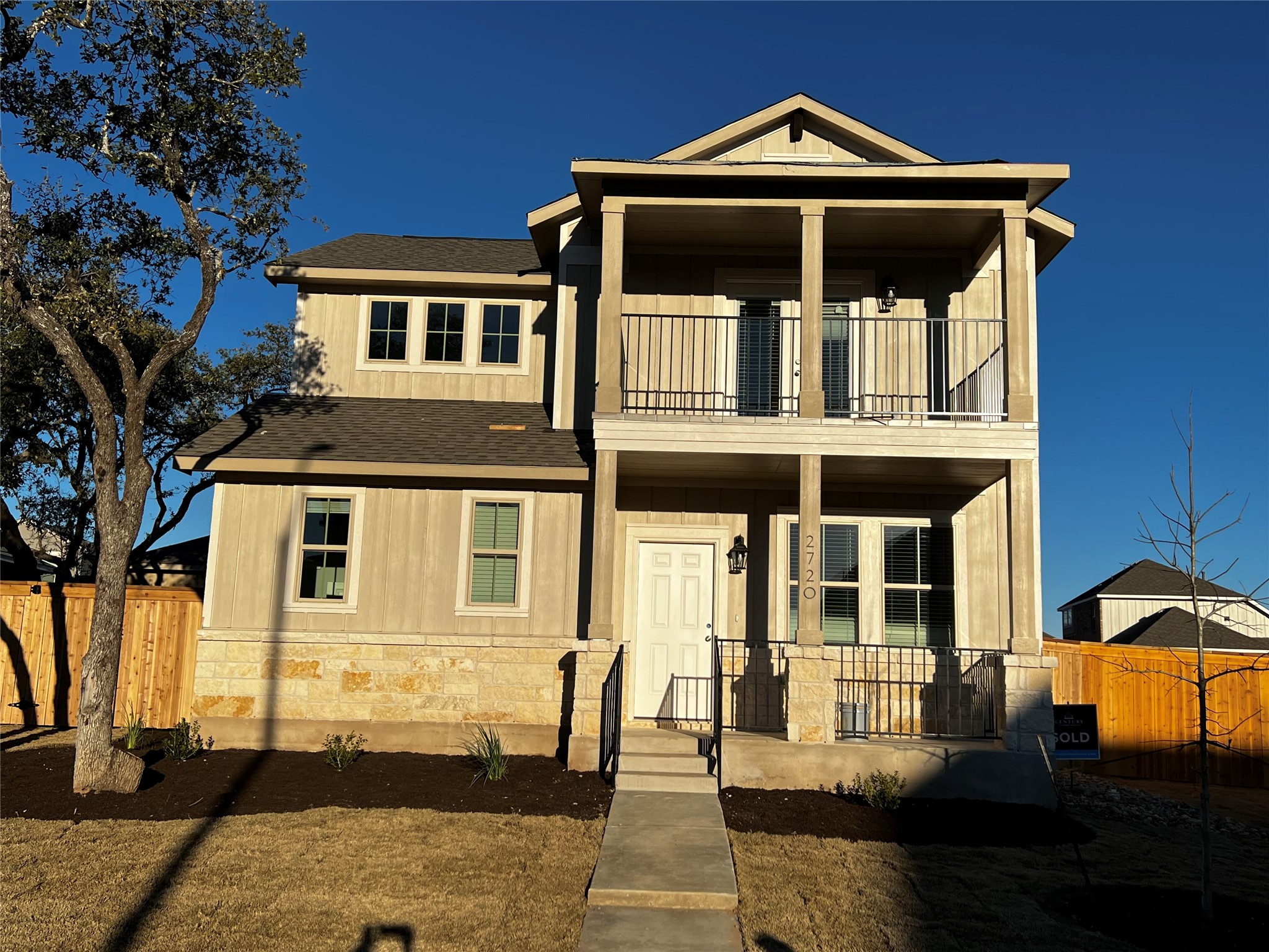 The property features a two-story facade with a stone base and vertical siding