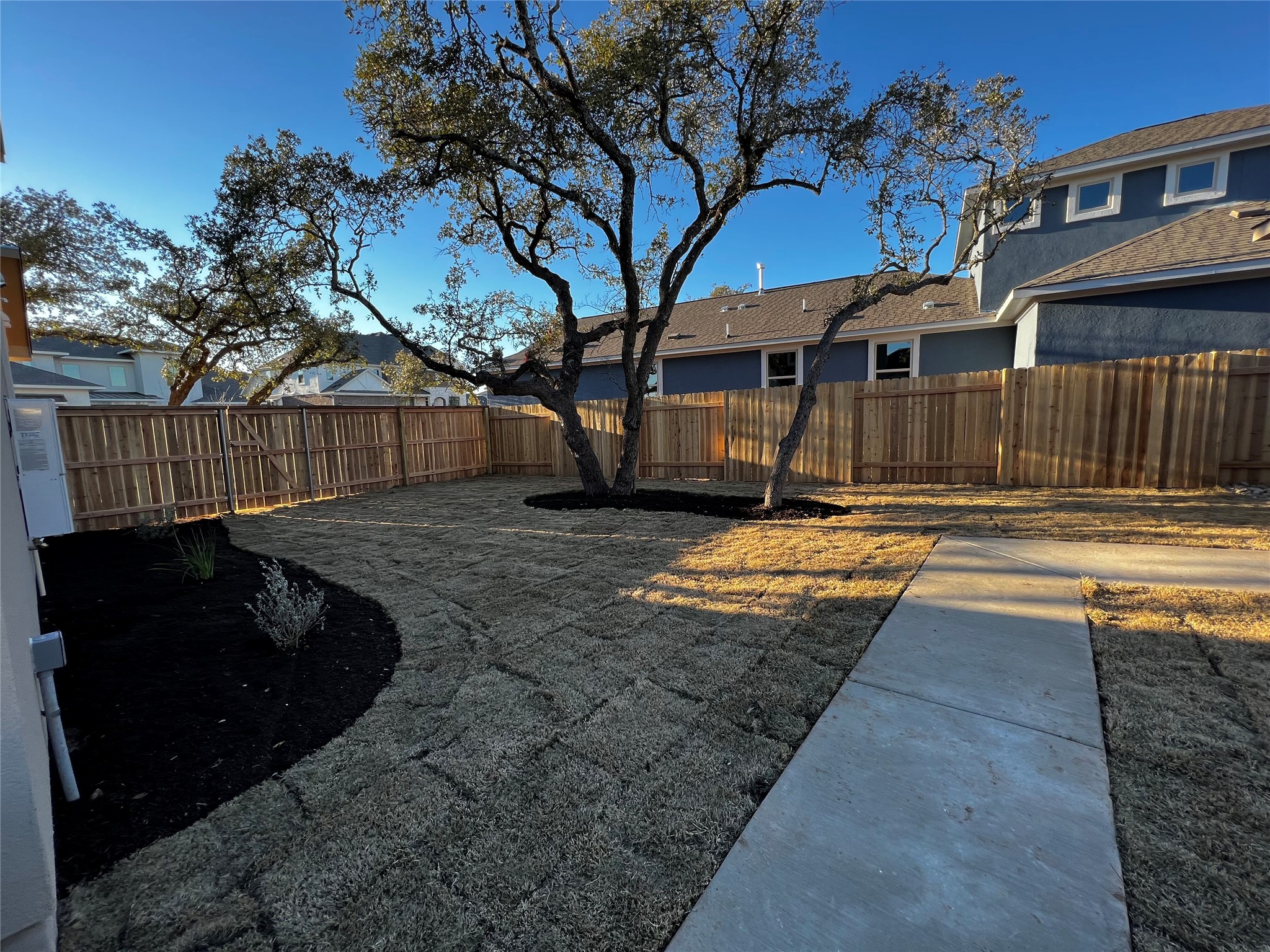 2720 Juniper Woods Road Leander, TX 78641 - Photo 4 of 8 The property features a spacious yard with a newly laid lawn, mature trees, and a wooden privacy fence