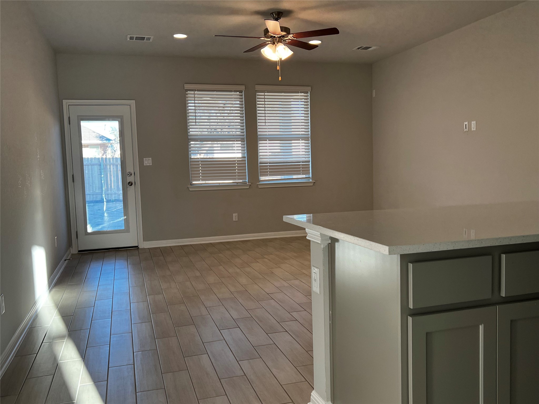 2720 Juniper Woods Road Leander, TX 78641 - Photo 8 of 8 The property features tile flooring, two windows with blinds, a ceiling fan, and a door with a glass pane