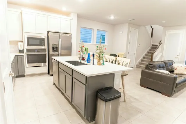 a kitchen with a sink refrigerator and cabinets