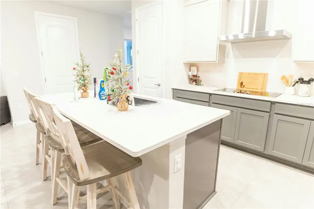 a kitchen with a sink a stove and white cabinets