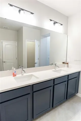 a bathroom with a double vanity sink and a mirror