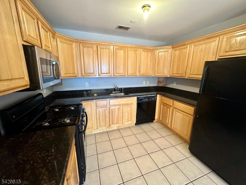 111 Harris Avenue, Unit 5 Middlesex, NJ 08846 - Photo 3 of 6 a kitchen with a sink a stove and a refrigerator