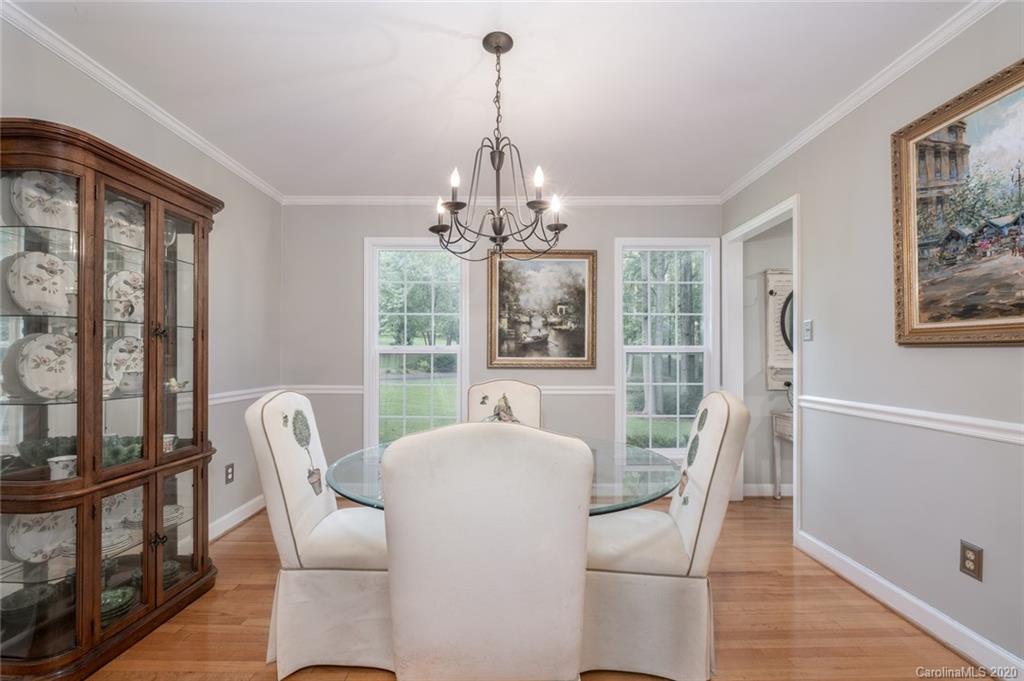 1130 Churchill Road Davidson, NC 28036 - Photo 13 of 38 a dining room with furniture a chandelier and wooden floor
