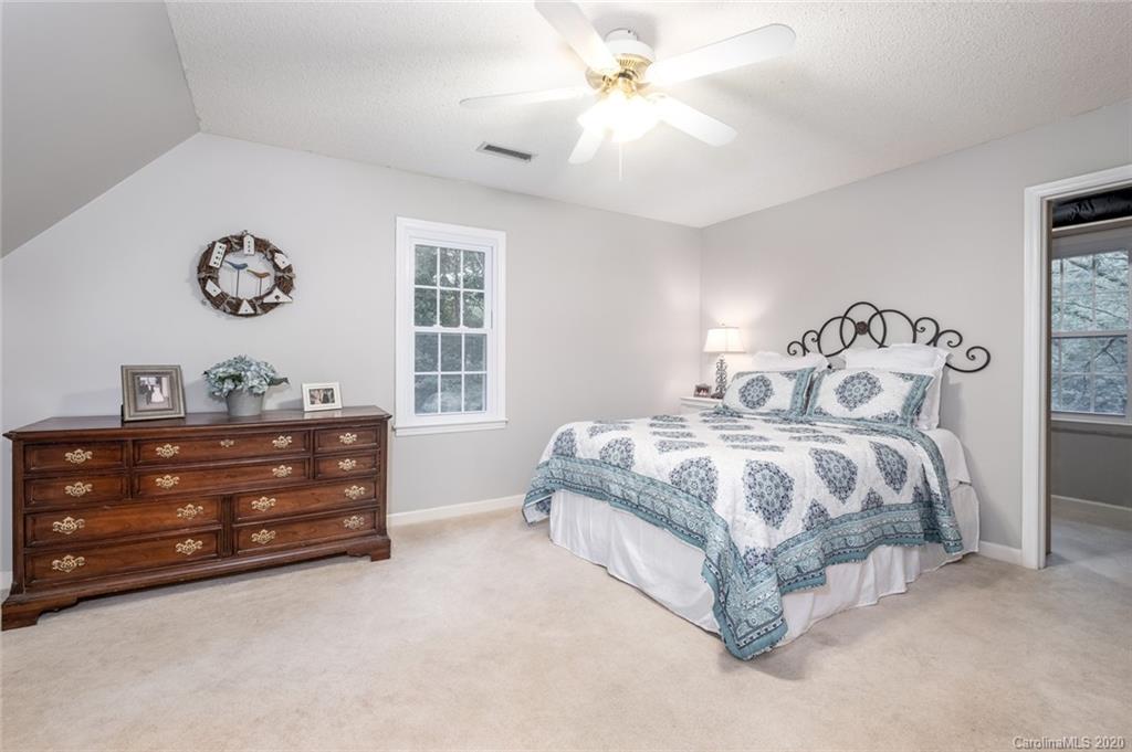 1130 Churchill Road Davidson, NC 28036 - Photo 26 of 38 a bedroom with a bed and a chandelier