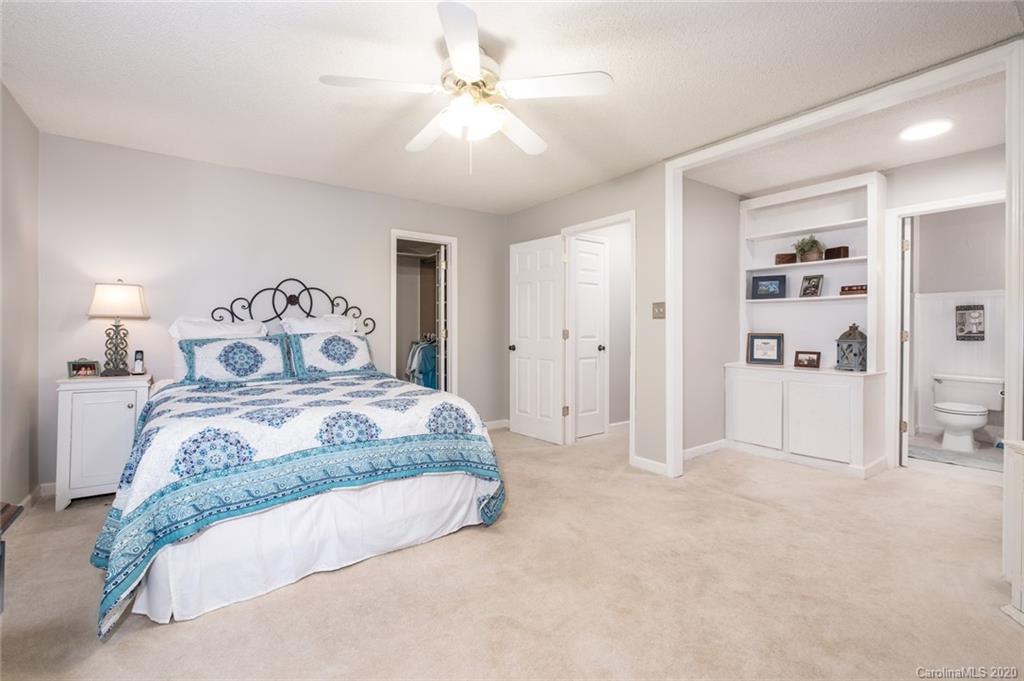 1130 Churchill Road Davidson, NC 28036 - Photo 27 of 38 a spacious bedroom with a bed and a chandelier