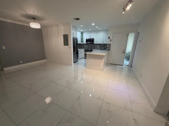 a kitchen with stainless steel appliances a refrigerator a stove a sink and a refrigerator