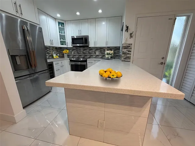a kitchen with stainless steel appliances a refrigerator and a stove top oven