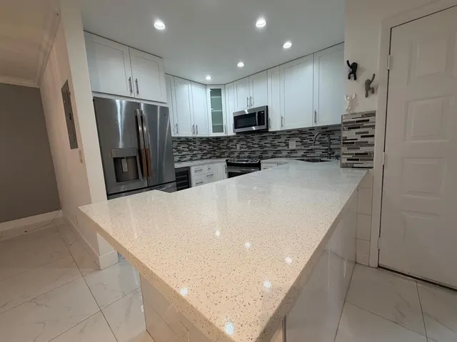 a kitchen with stainless steel appliances white cabinets and a stove top oven
