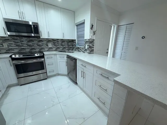 a view of cabinets and utility room with closet