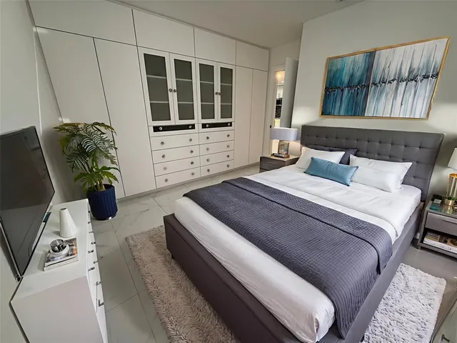 a bedroom with a bed and a flat screen tv