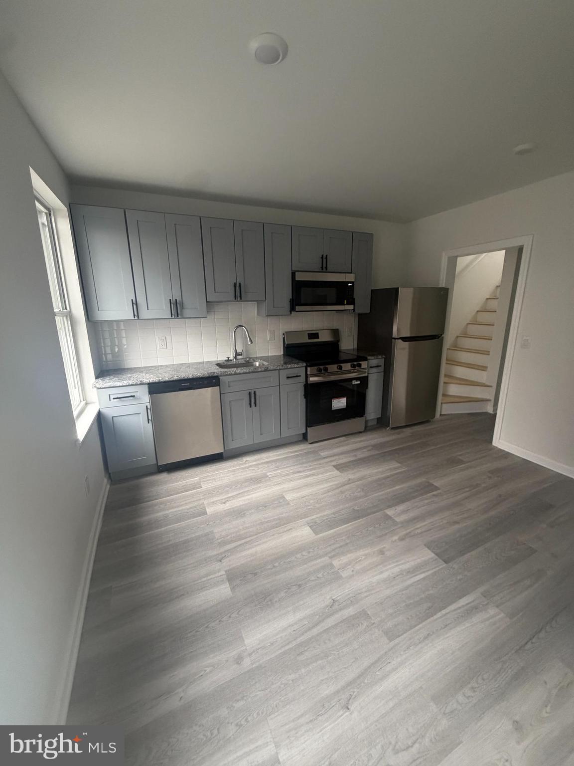 112 East Huntingdon Street, Unit 2 Philadelphia, PA 19125 - Photo 1 of 12 a kitchen with kitchen island white cabinets and wooden floor