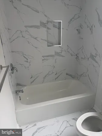 a white bath tub sitting next to a white sink and vanity