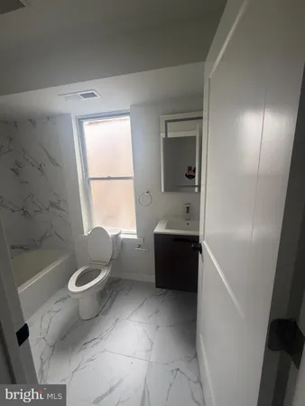 a bathroom with a tub toilet and sink