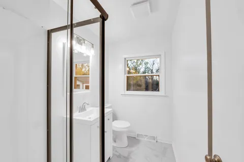 a bathroom with a toilet shower and a sink
