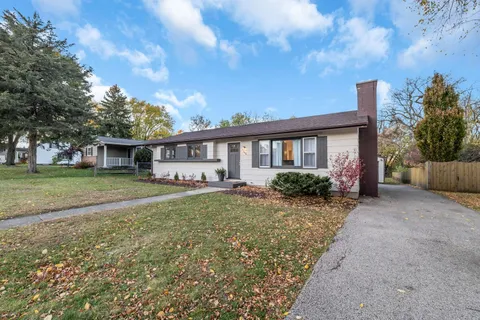 a view of a house with backyard and trees