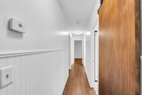 a view of a hallway with wooden floor