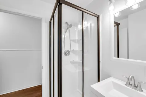 a bathroom with a glass shower door and a sink