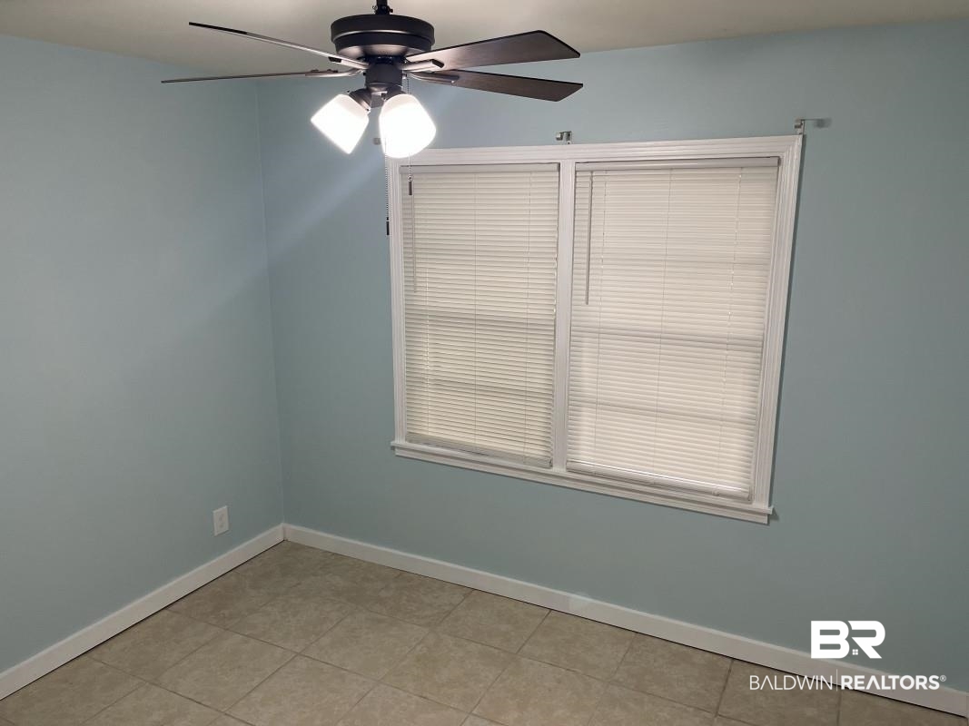 609 East Orange Avenue Foley, AL 36535 - Photo 5 of 6 Spare room with light tile patterned floors and ceiling fan