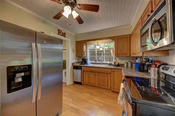 a kitchen with stainless steel appliances granite countertop a refrigerator a stove and a sink with cabinets