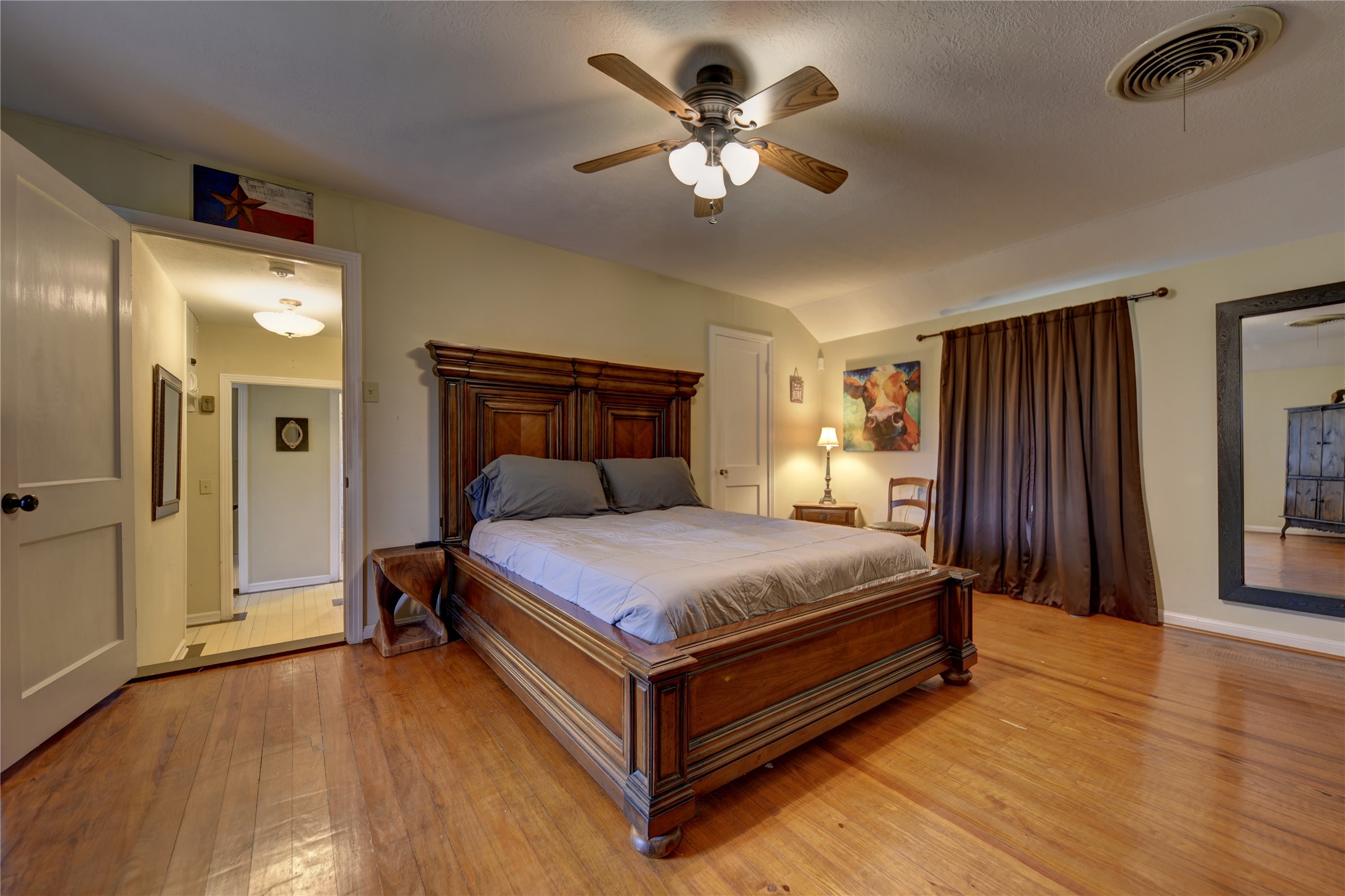 706 South Market Street Brenham, TX 77833 - Photo 20 of 27 a bedroom with a bed and a chandelier