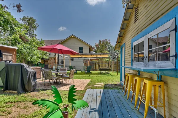 a backyard of a house with barbeque oven table and chairs