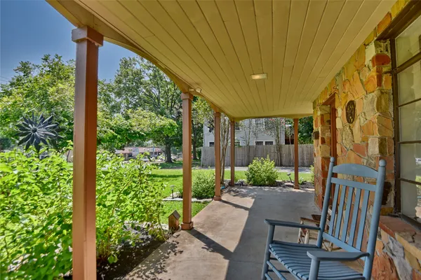 a patio with table and chairs and potted plants