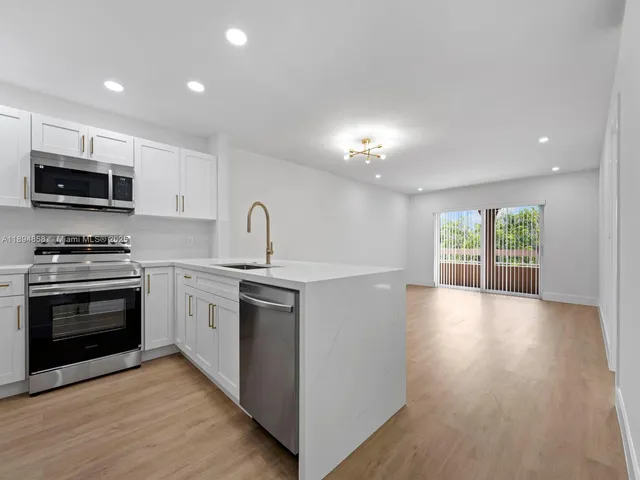 a kitchen with granite countertop a stove and a sink