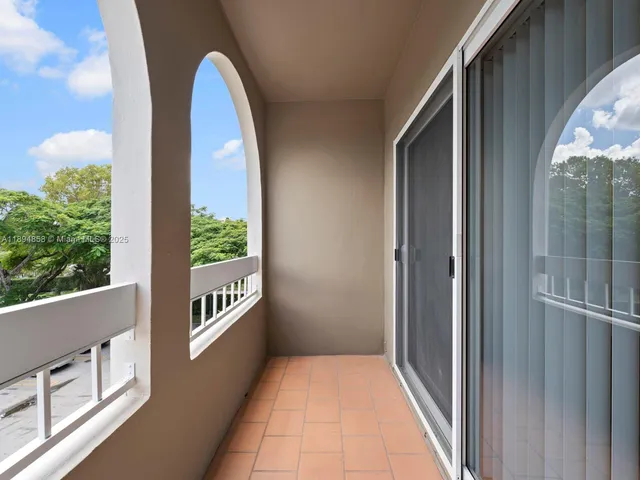 an outdoor sitting area with furniture and umbrella
