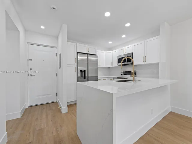 a kitchen with stainless steel appliances a refrigerator and a stove top oven
