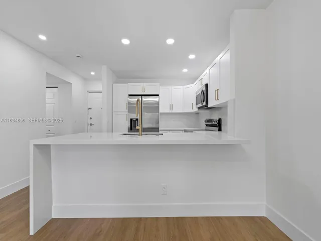 a kitchen with stainless steel appliances a sink stove and cabinets