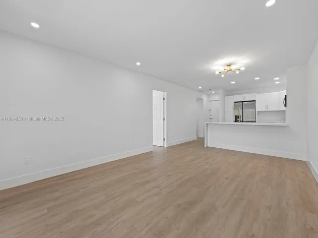 a view of a kitchen with a sink and a refrigerator