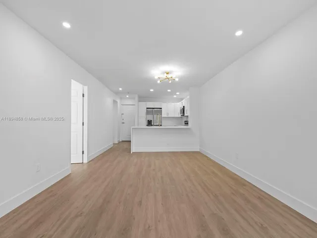 wooden floor in an empty room with a kitchen