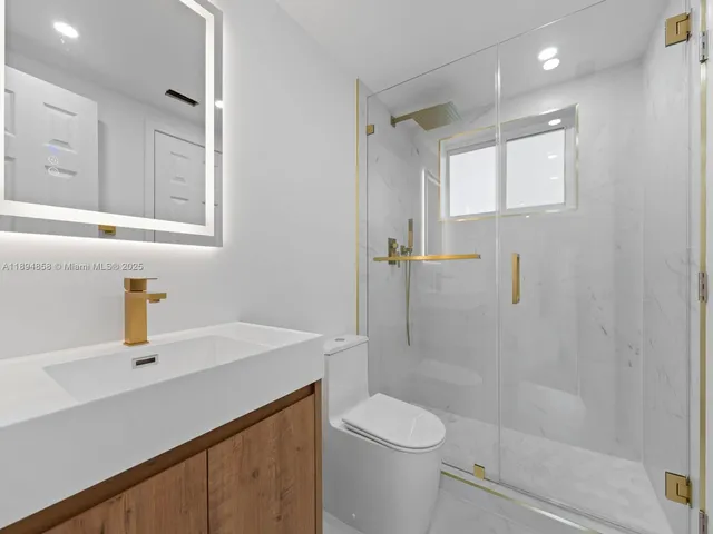 a bathroom with a sink a toilet and shower