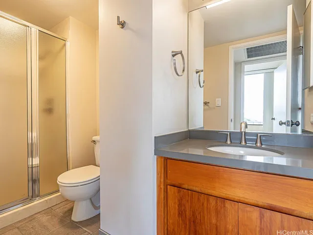 a bathroom with a granite countertop sink toilet and shower