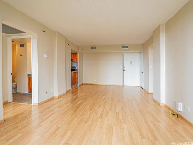 a view of empty room with wooden floor