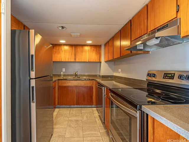 a kitchen with stainless steel appliances granite countertop a refrigerator a stove and a sink