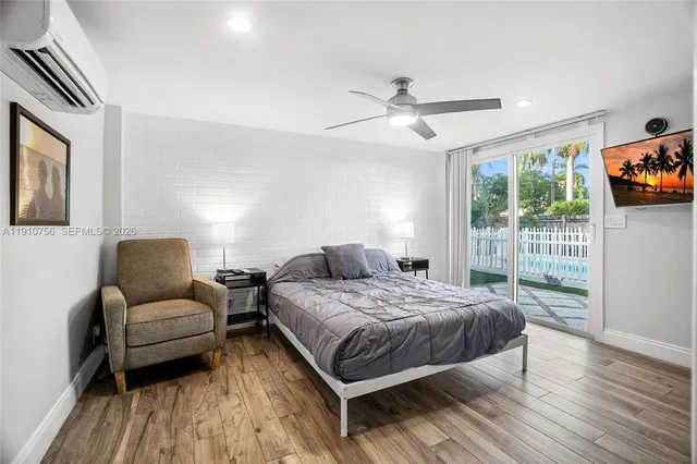 a bedroom with a bed wooden floor and window