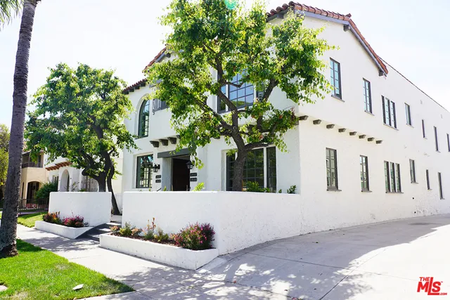 a view of a white house with a tree in front