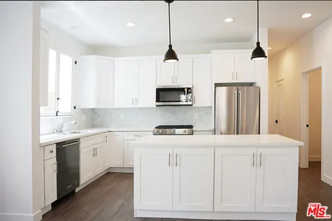 a kitchen with white cabinets and stainless steel appliances