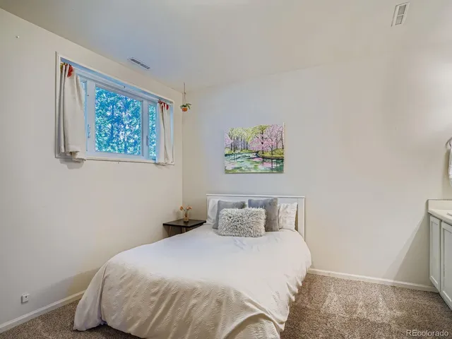 a bedroom with a bed and painting on the wall