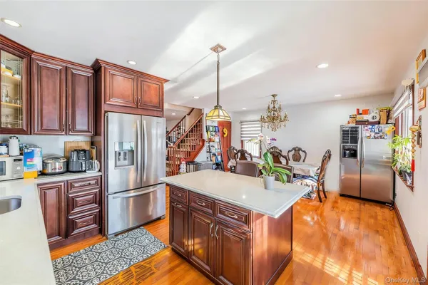 a kitchen with stainless steel appliances granite countertop a refrigerator a stove and a sink