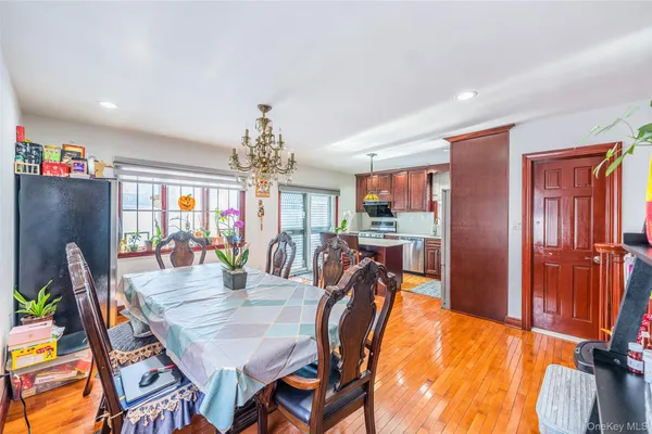 a dining room with furniture a chandelier and wooden floor