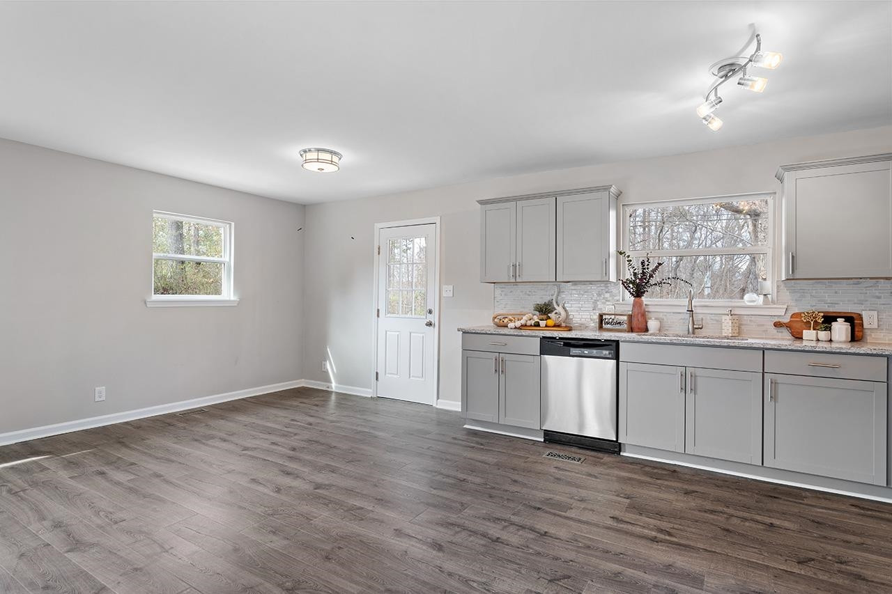 1101 Springdale Drive Durham, NC 27707 - Photo 6 of 24 a kitchen with granite countertop white cabinets a sink a window and stainless steel appliances