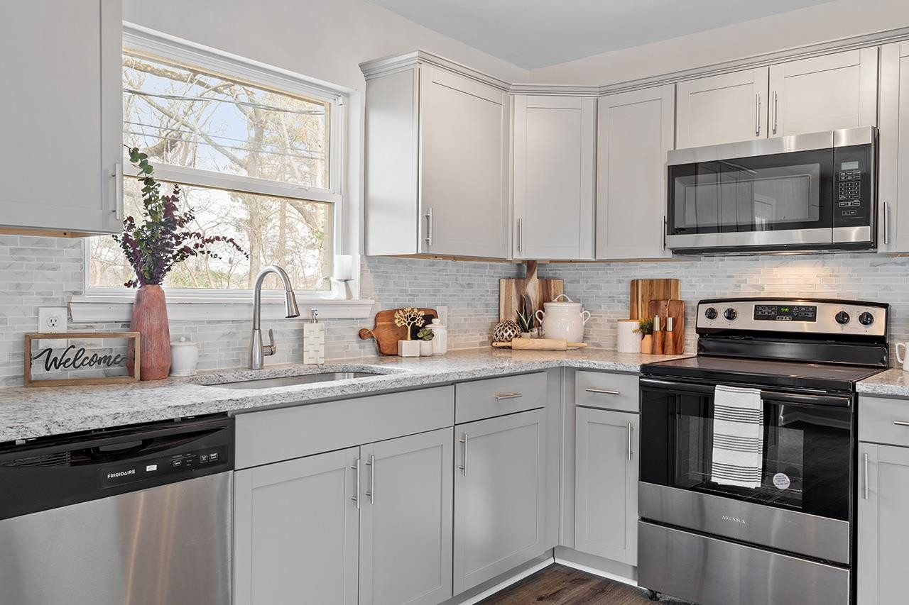 1101 Springdale Drive Durham, NC 27707 - Photo 9 of 24 a kitchen with stainless steel appliances granite countertop white cabinets a microwave oven and a sink