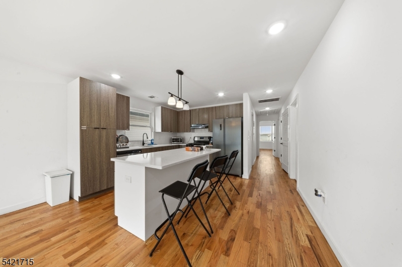 735 Seaport Drive, Unit 2 Elizabeth, NJ 07201 - Photo 13 of 28 a kitchen with kitchen island white cabinets and stainless steel appliances