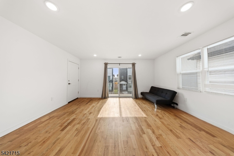 735 Seaport Drive, Unit 2 Elizabeth, NJ 07201 - Photo 10 of 28 wooden floor in an empty room with a window